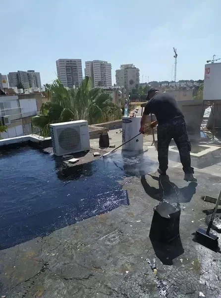 איטום גג שטוח בערד - משטח בטון בהיר עם קווי איטום נקיים ונוף מדברי ברקע